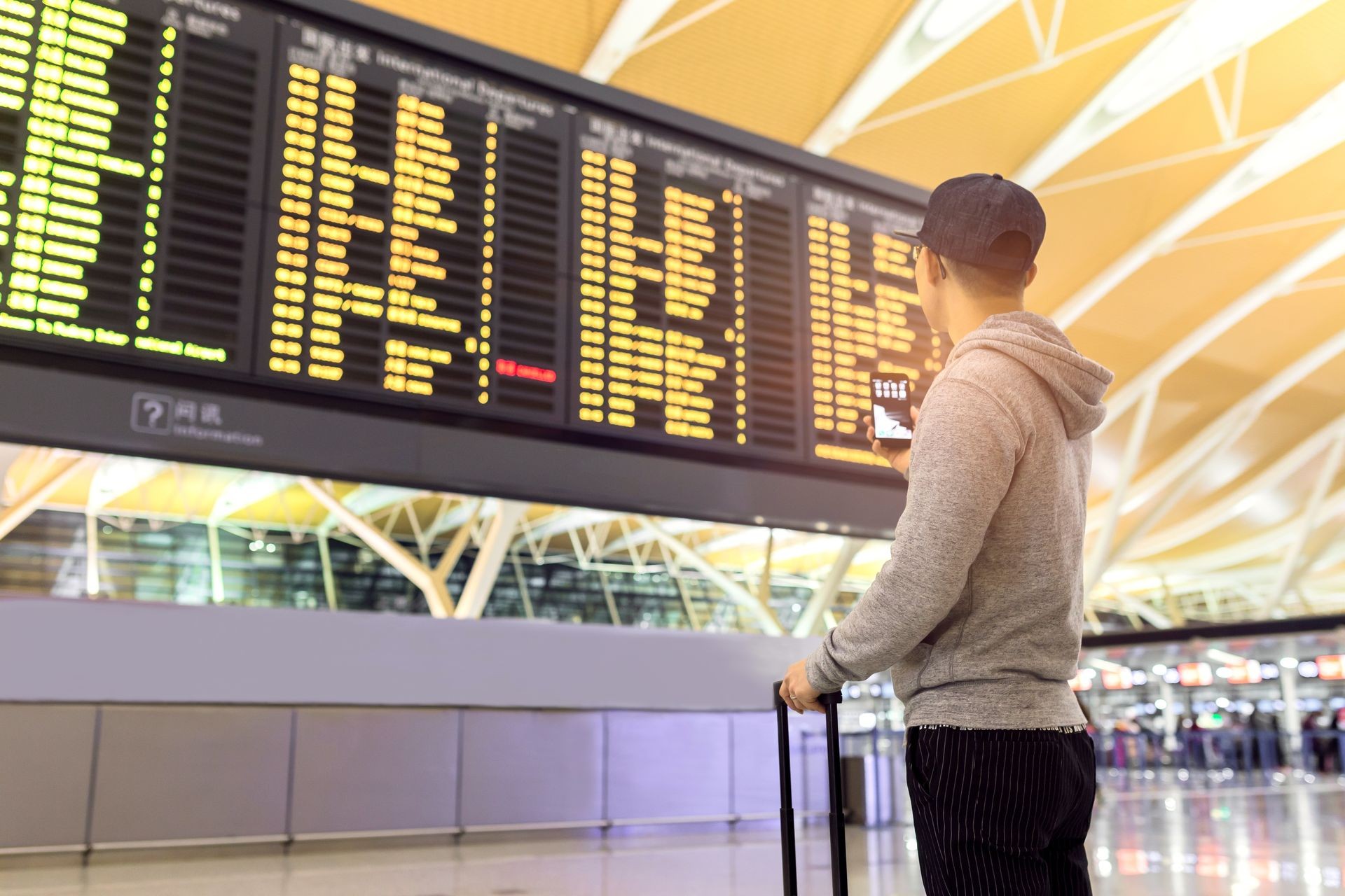 Passenger looking at departures board in airport terminal at dubai and Abu Dhabi 